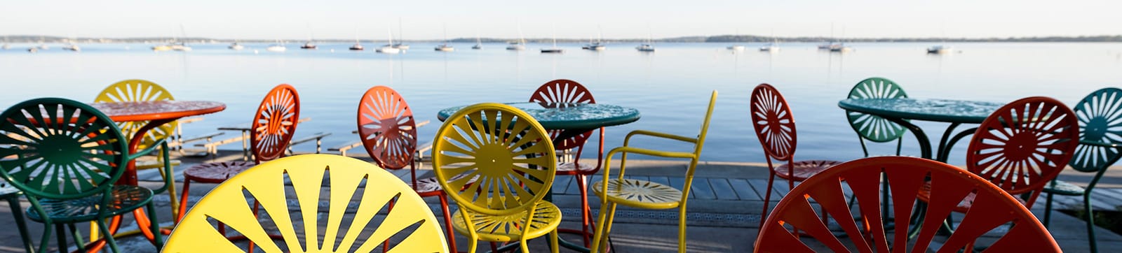 Colorful Terrace chairs sit empty on the Memorial Union Terrace with Lake Mendota in the background.