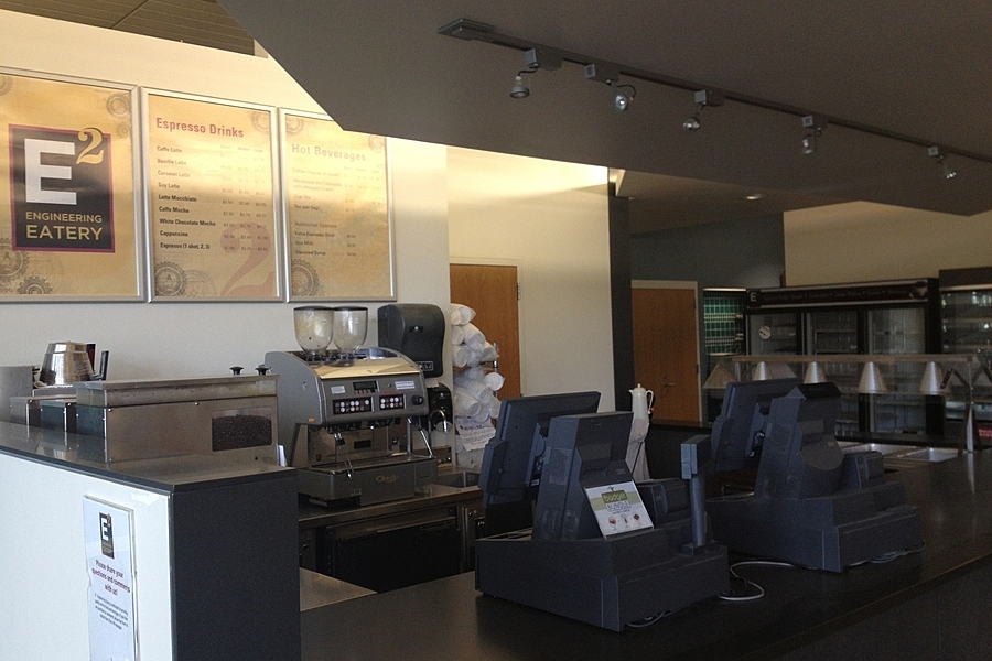 Sales counter with coffee machine in background and menu fixed to wall. 
